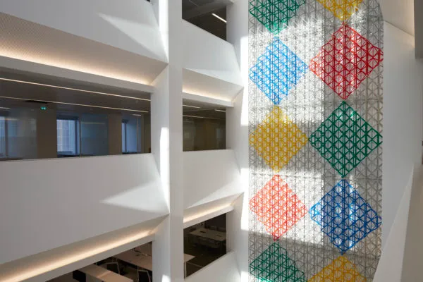 The inside of the Aga Khan Centre, with offices open at the side and Rhapsody in Four Colours, a work of art that features coloured diamonds built of industrial materials, running the entire height of the building.