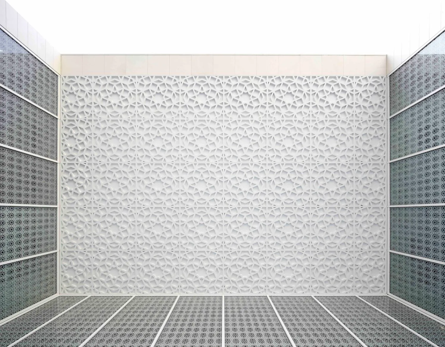 The view looking up in the Garden of Tranquillity. This features glass walls with Islamic patterns and a white ceiling with embossed Islamic patterns.
