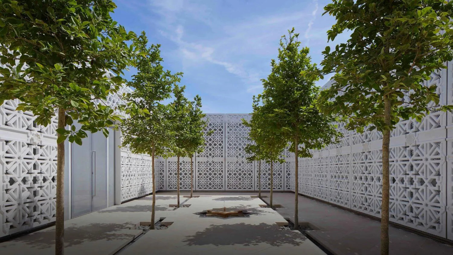 The Garden of Light - an Islamic garden with white walls and six green magnolia trees with fountain between them.