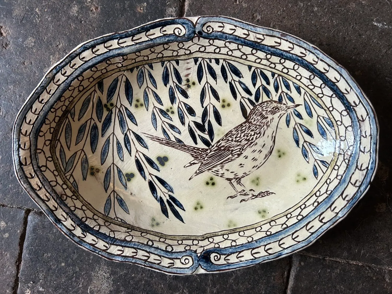 A plate featuring leaves and a bird.